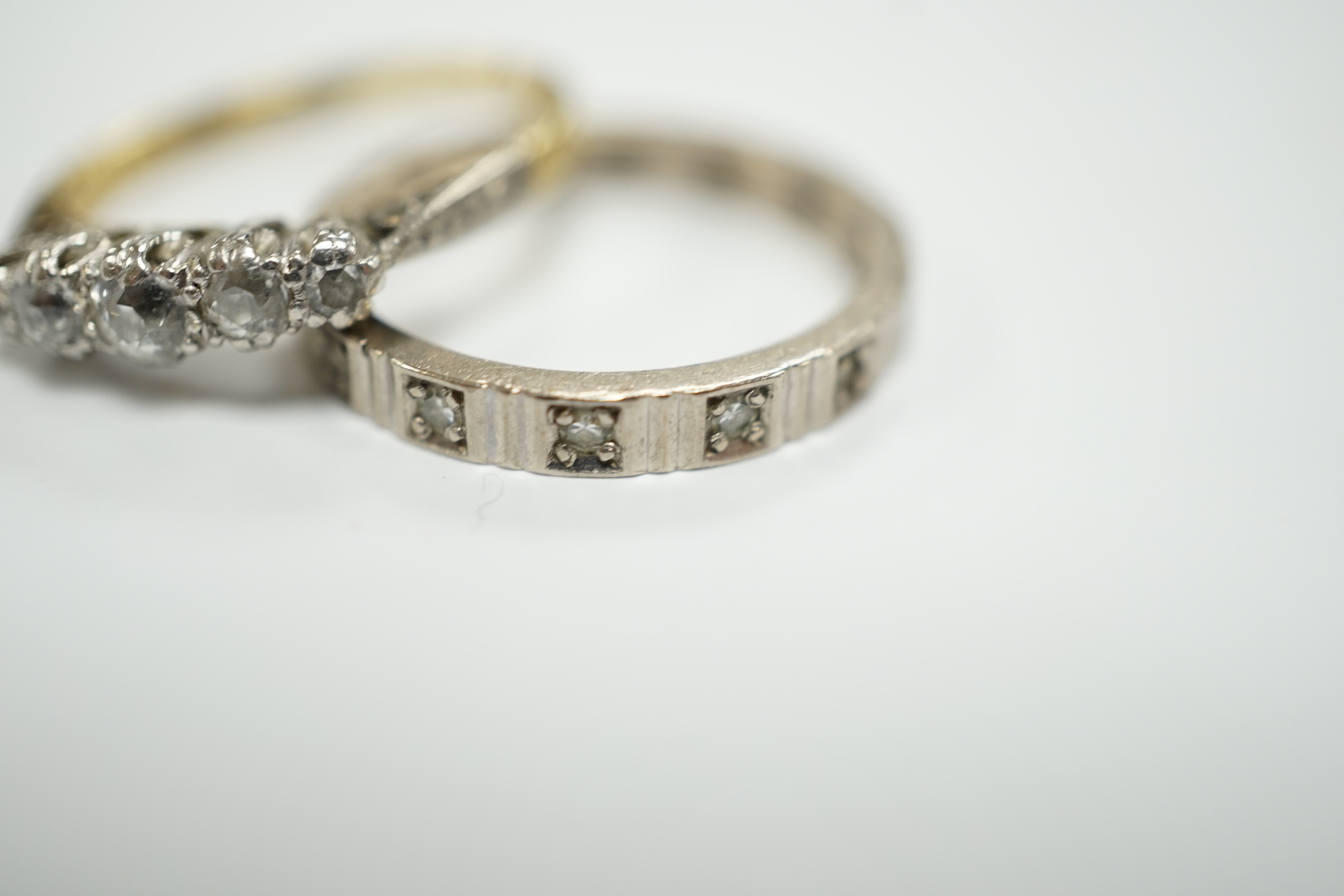 A 750 white metal and diamond chip set full eternity ring and an 18ct and graduated five stone diamond chip set ring, gross weight 6.6 grams.